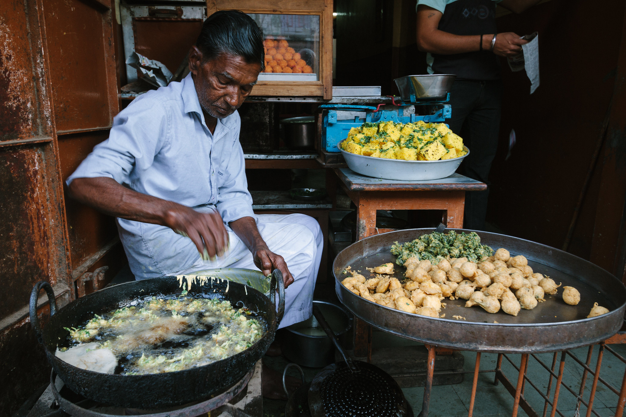 A man frying food in pans of hot oil