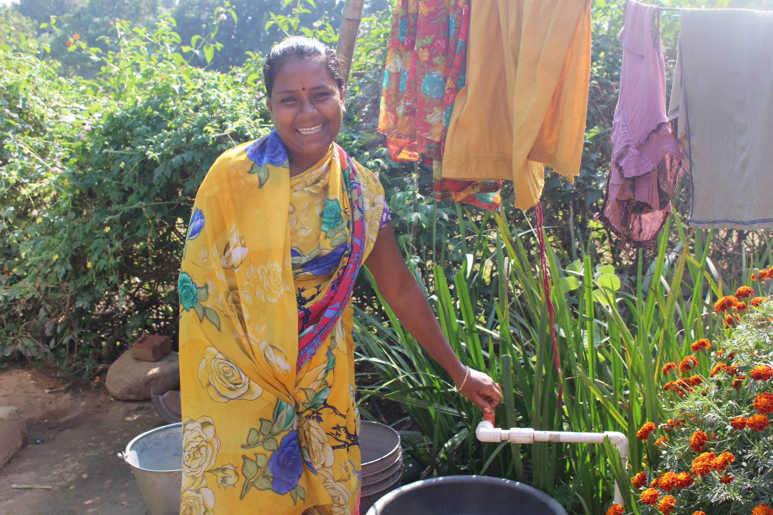 A woman operating a water tap.