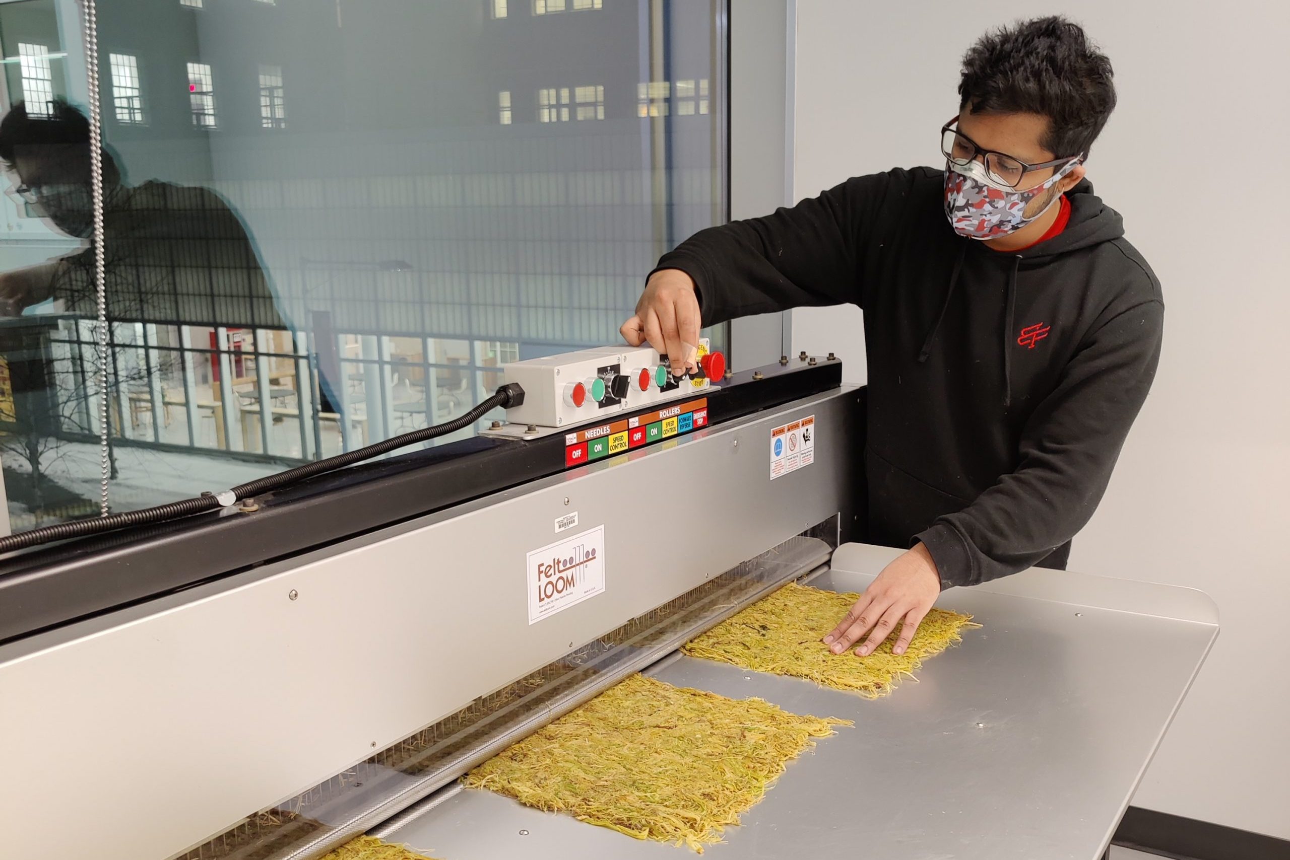 A man operating a machine making mats of straw