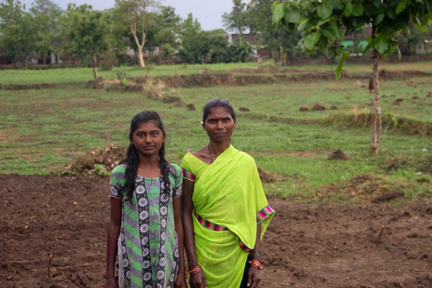 A mother and daughter standing on farmland