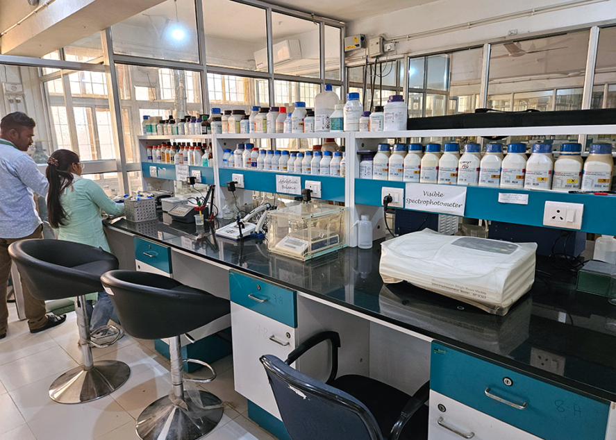 Two people standing by equipment in a lab