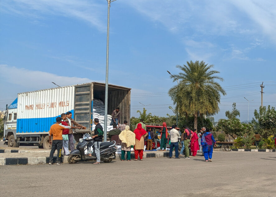 Bags of grain are distributed from a truck