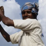 A farmer winnowing millet