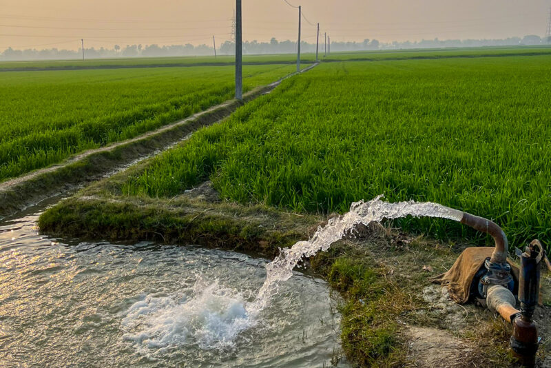 Water being pumped into an irrigation ditch on farmland