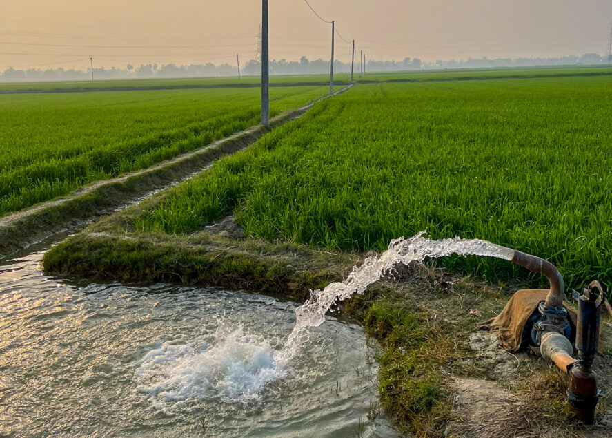 Water being pumped into an irrigation ditch on farmland