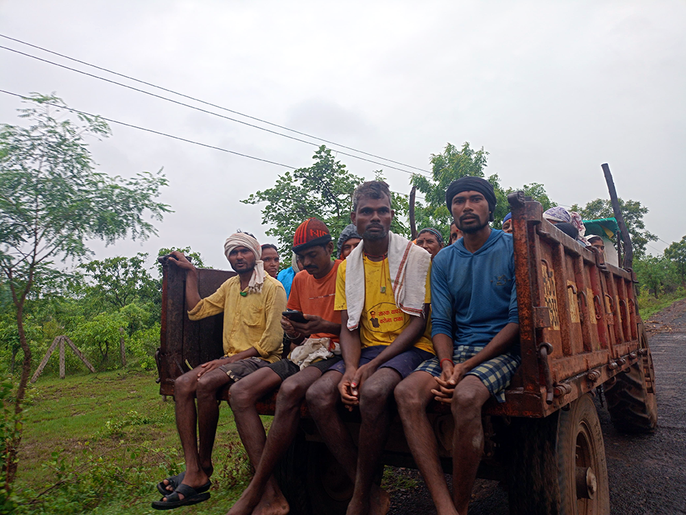 Migrant laborers sitting on the back of a truck