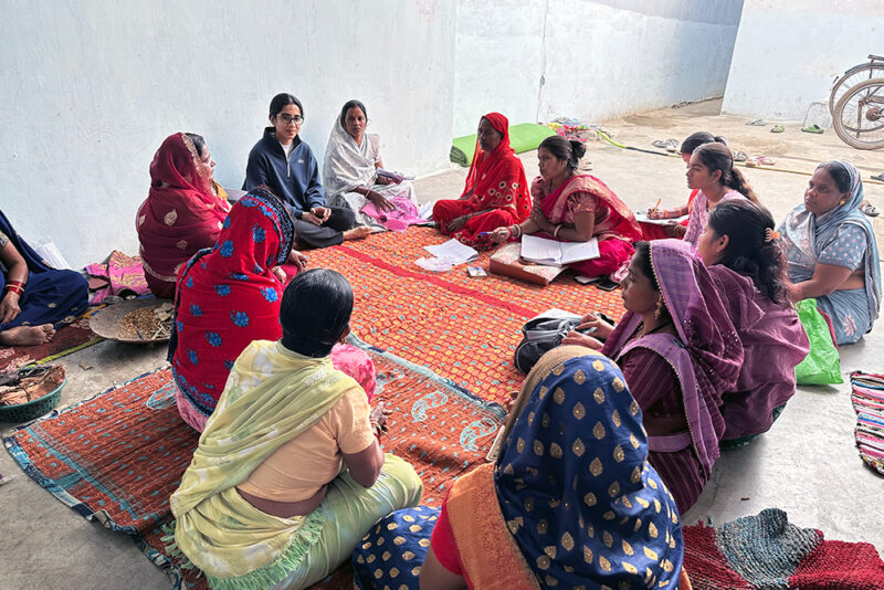 Annie Kaur sitting in a circle with a group of women