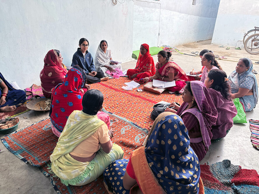 Annie Kaur sitting in a circle with a group of women