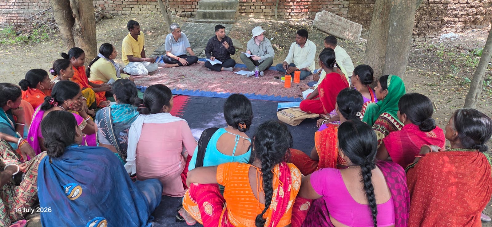 Harrison Sachs sitting in a circle with members of a women's self-help group